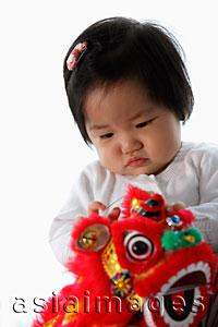 Asia Images Group - Baby holding red Chinese dragon toy