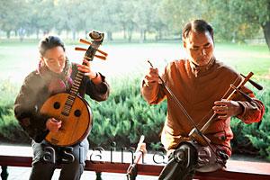 Asia Images Group - China,Beijing,Temple of Heaven Park, Man and Woman Playing Traditional Chinese Stringed Instruments