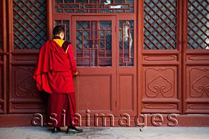 Asia Images Group - Tibetan Lama Temple or Yonghe Gong, Monk Opening Door. Beijing China