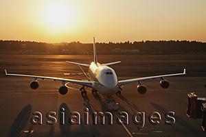 Asia Images Group - Airplane on tarmac, sun behind. Narita Airport, Japan