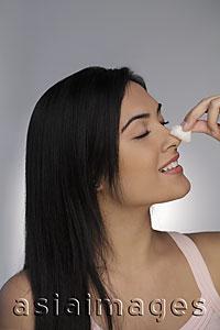 Asia Images Group - Profile of young woman cleaning her face with cotton ball