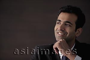 Asia Images Group - Head shot of young man with hand on his chin smiling