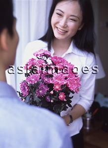 Asia Images Group - Woman holding bouquet of flowers, man in foreground