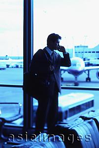 Asia Images Group - Male executive talking on cellular phone in airport lounge