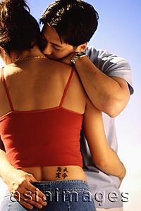 Asia Images Group - Couple embracing, woman with tattoo of Chinese characters on waist