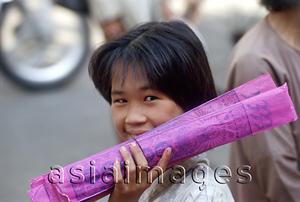 Asia Images Group - Vietnam, Lao Cai, young woman selling packs of incense sticks.