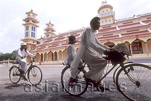Asia Images Group - Vietnam, Tay Ninh, worshippers on bicycle outside Cao Dai Great Temple.