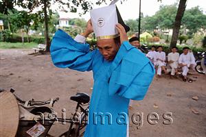 Asia Images Group - Vietnam, Tay Ninh, Cao Dai priest arranging hat.