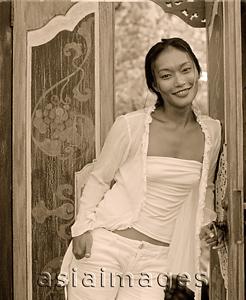 Asia Images Group - Woman standing in doorway, smiling