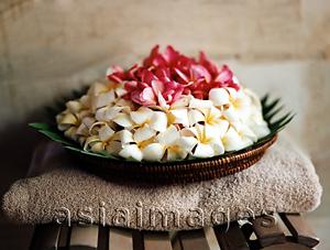 Asia Images Group - Basket of flowers sitting on towel.