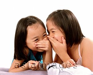 Asia Images Group - Two young girls laughing, white background.