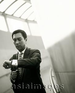 Asia Images Group - Male executive looking at watch.