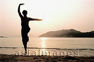 Asia Images Group - Silhouette of man doing Kung Fu moves at beach