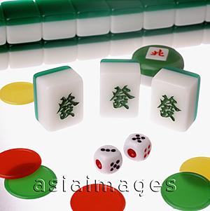 Asia Images Group - Mahjong tiles, dice and chips on a lit table
