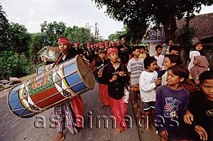 Asia Images Group - Indonesia, Lombok, Drummers leading a wedding procession past a crowd on the street.