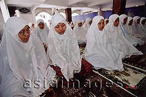 Asia Images Group - Indonesia, Jakarta, Young students at the Asshiddiqiyah Muslim School kneeling for prayers.