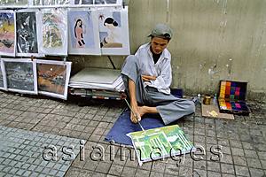 Asia Images Group - Vietnam, Ho Chi Minh City, A handicapped artist on a sidewalk drawing with his feet.