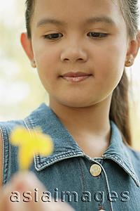 Asia Images Group - Young girl holding a flower