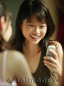Asia Images Group - Young woman using mobile phone.