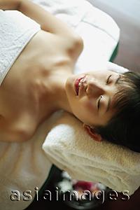 Asia Images Group - Young woman lying down on massage table