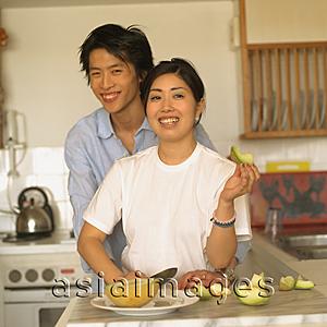 Asia Images Group - Couple at home, standing in kitchen