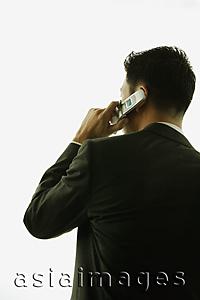 Asia Images Group - Young man, rear view, using mobile phone