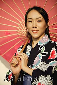 Asia Images Group - Young woman in kimono, holding an umbrella