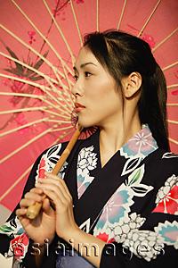 Asia Images Group - Young woman in kimono, holding an umbrella