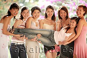 Asia Images Group - Group of young women, posing for camera, carrying one girl between them