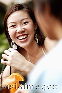 Asia Images Group - Young woman with a drink, smiling