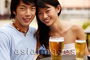 Asia Images Group - Couple sitting at cafe, cheek to cheek, looking at camera