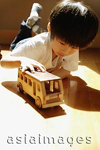 Asia Images Group - Young boy playing with toy bus