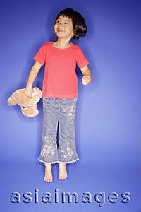 Asia Images Group - Young girl jumping, holding teddy bear