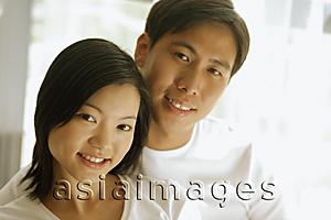 Asia Images Group - Couple sitting side by side, looking at camera