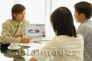 Asia Images Group - Young man showing laptop to couple in front of him