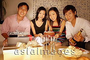 Asia Images Group - Couples sitting down, looking at camera, cake in front of them