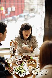 Asia Images Group - Young woman and friends at a Chinese restaurant