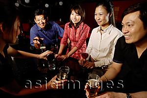 Asia Images Group - Couples drinking at bar, bartender serving them