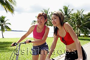 Asia Images Group - Two women on bicycles, side by side, looking forward