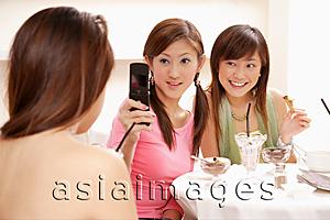Asia Images Group - Young women holding camera phone, photo messaging