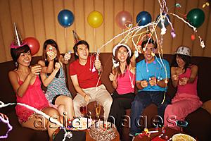 Asia Images Group - Young adults celebrating with crackers, party hats and balloons
