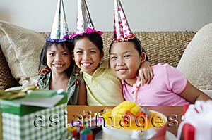 Asia Images Group - Three girls with party hats sitting side by side