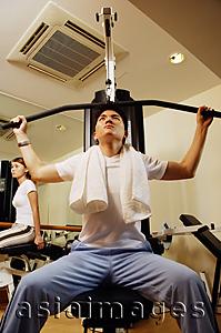 Asia Images Group - Man using exercise machine, low angle view