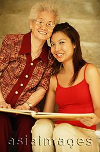 Asia Images Group - Grandmother with granddaughter, holding picture album