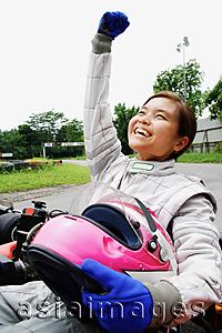 Asia Images Group - Young woman in go-cart, hands outstretched, smiling, looking away