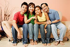Asia Images Group - Family of four sitting side by side, looking at camera, portrait