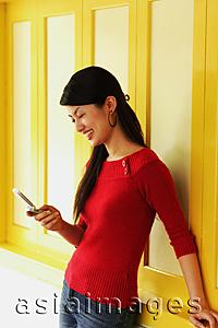 Asia Images Group - Young woman using mobile phone, text messaging