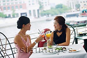 Asia Images Group - Two women having lunch, toasting with drinks