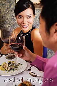 Asia Images Group - Couple in restaurant holding wine glasses for a toast