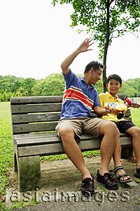 Asia Images Group - Father and son holding remote control cars, smiling